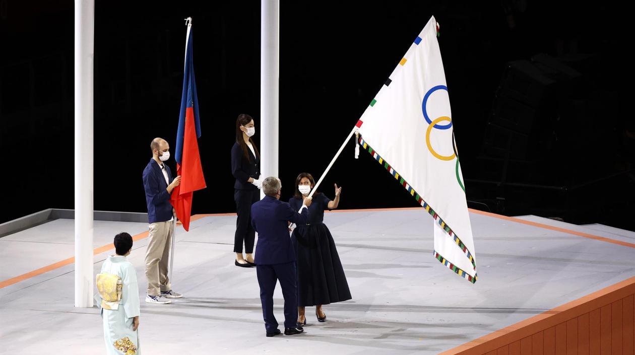 Anne Hidalgo, alcaldesa de París, toma la bandera olímpica de manos de Thomas Bach, presidente del COI. 
