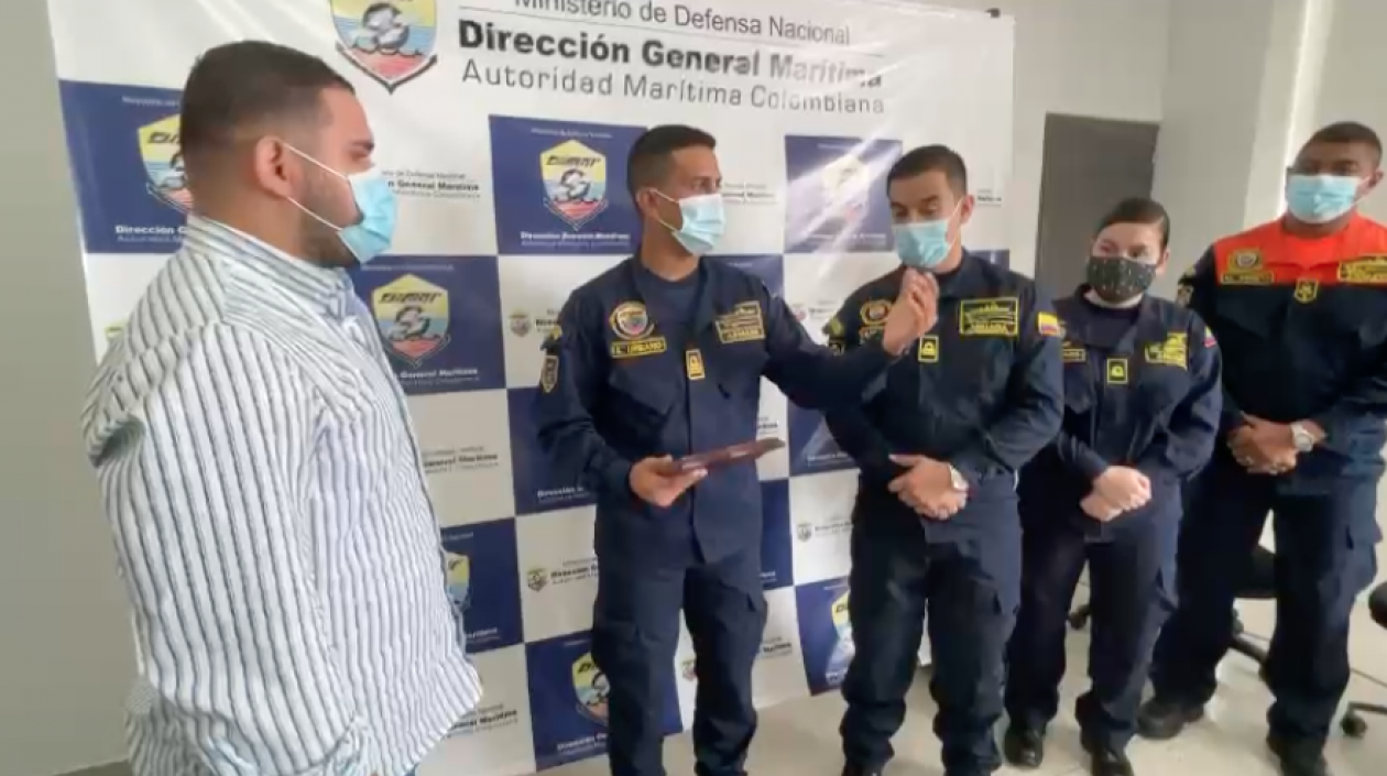 Daniel Pereira de la Oficina de Desarrollo de Puerto Colombia entrega el reconocimiento al capitán de fragata Carlos Urbano Montes, de la Dimar.
