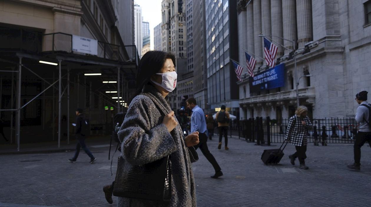 Una mujer camina con mascarilla en Nueva York.