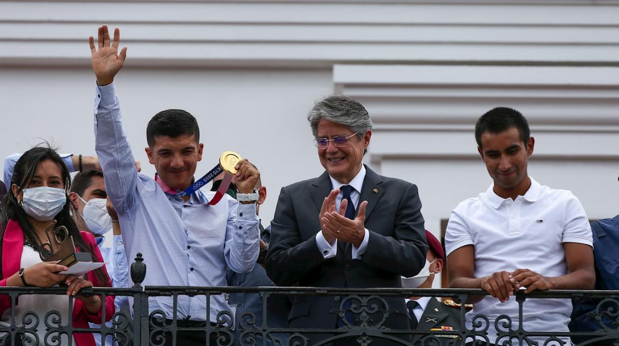 El ciclista ecuatoriano Richard Carapaz muestra su medalla olímpica, acompañado del presidente de Ecuador Guillermo Lasso (c) y del ciclista Jhonatan Narváez.