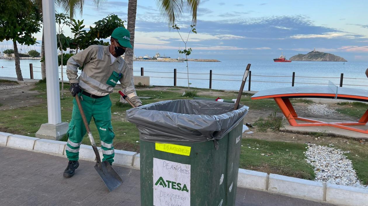 Colaborador de Atesa limpiando la zona de una playa. 