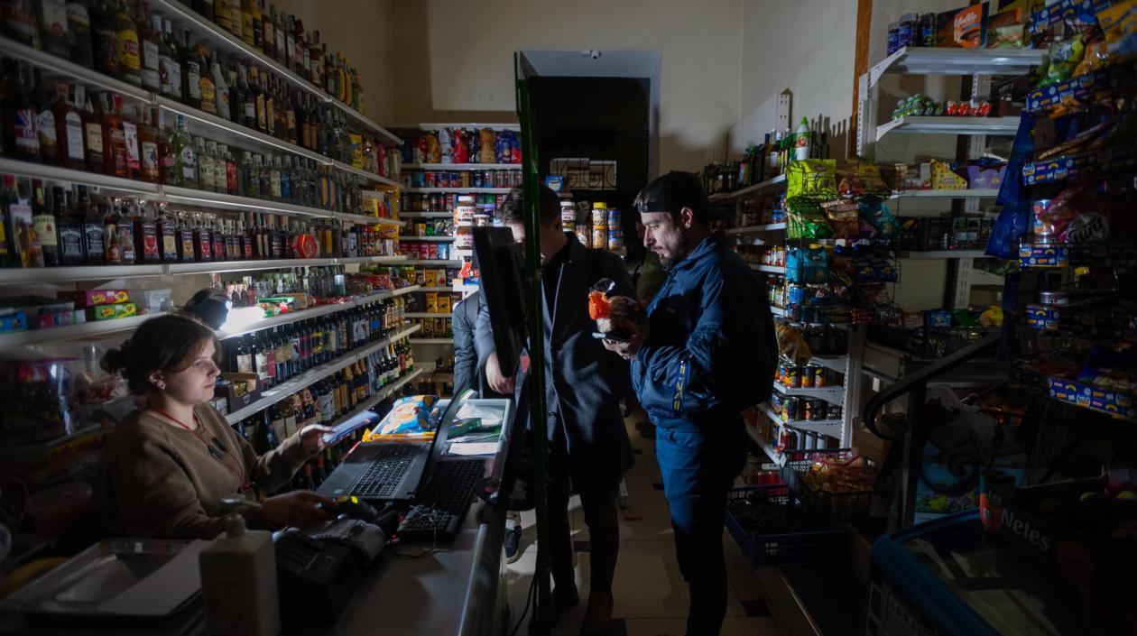 Personas compran productos en una tienda durante un apagón en Leópolis, en Ucrania.