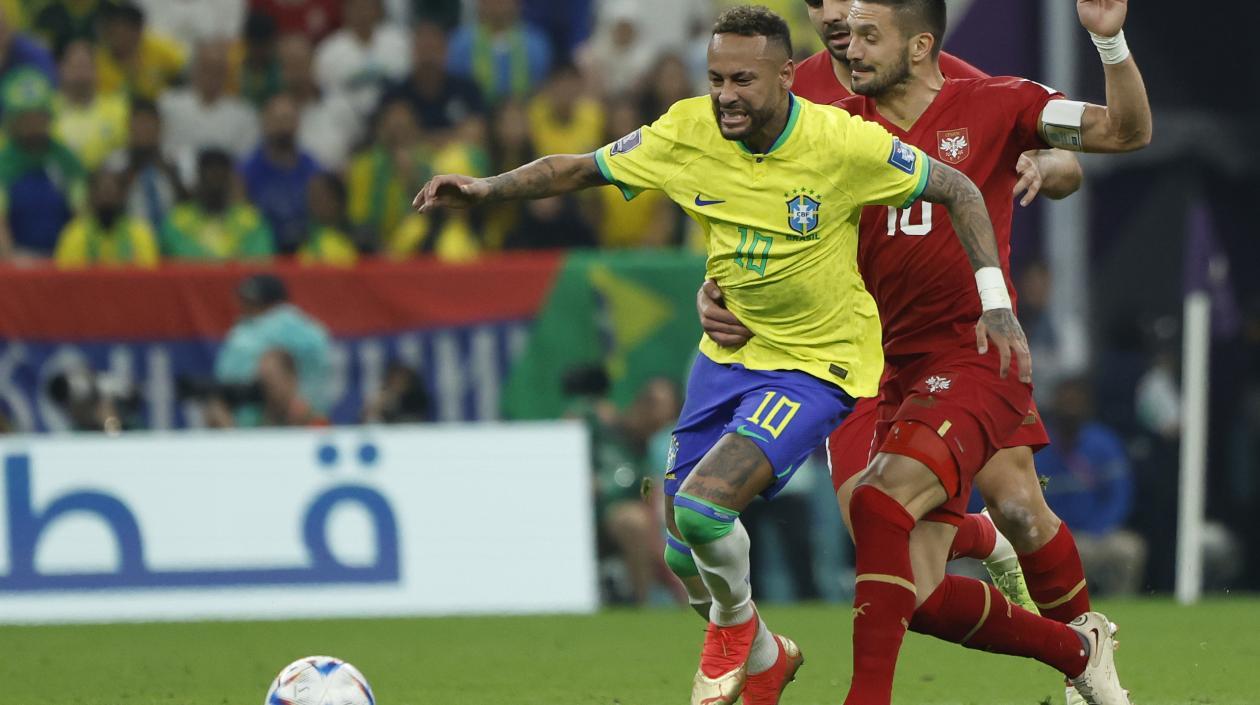 Neymar, quien se fue lesionado, avanza ante la marca de un rival serbio.