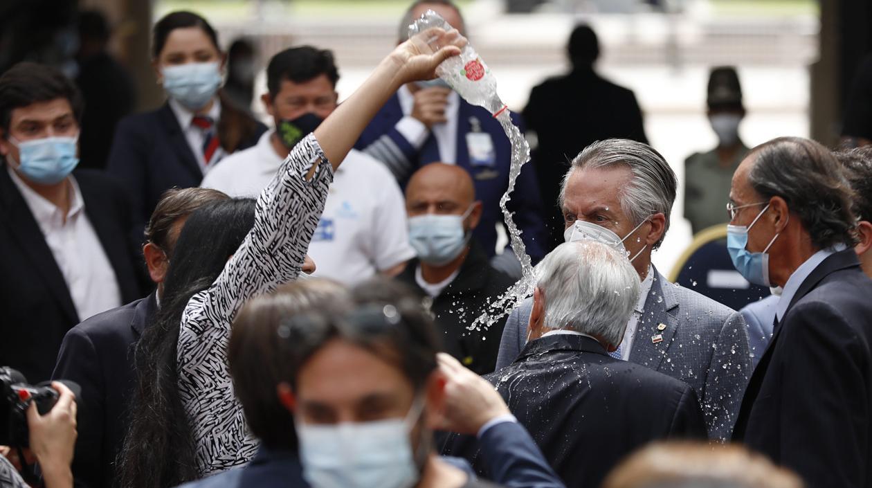 Momento en que la mujer arroja agua sobre la cabeza al presidente de Chile.