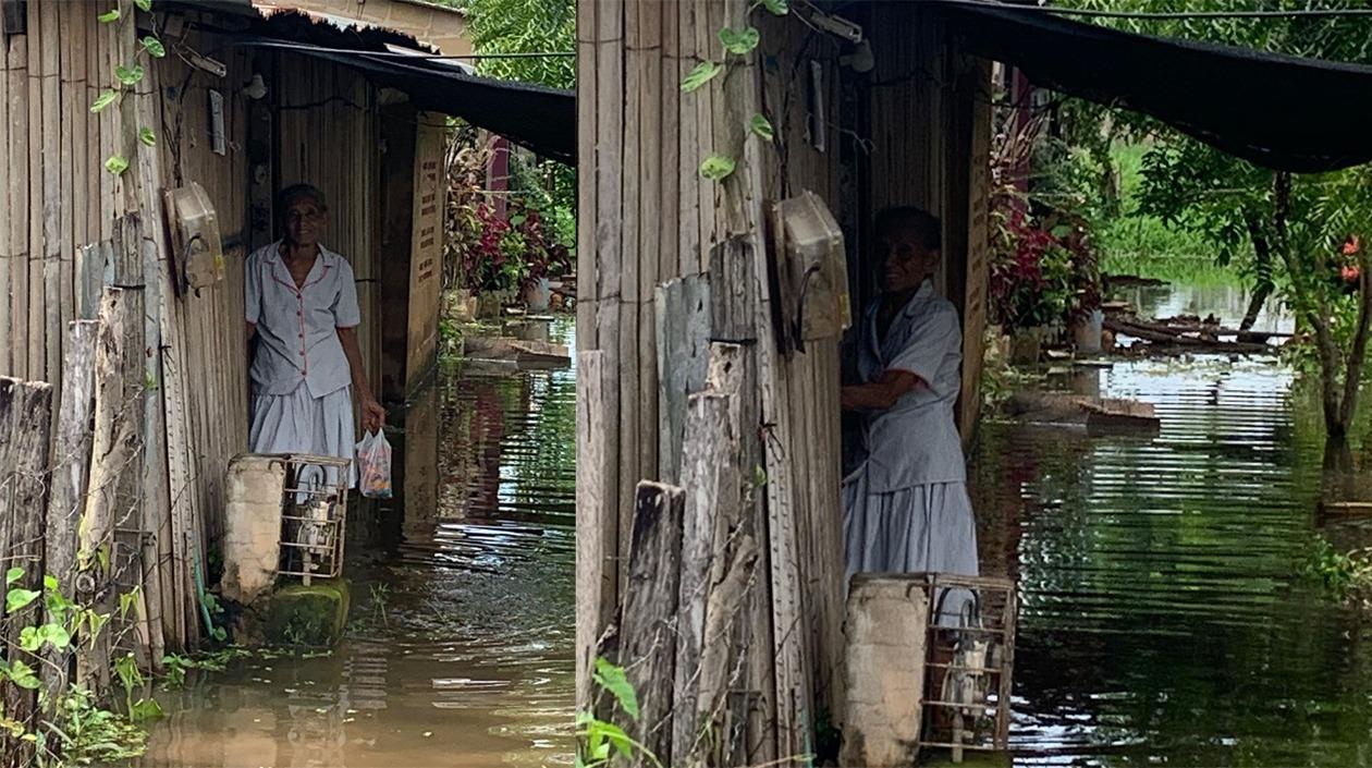 Una damnificada de la Mojana Sucreña es captada en el frente de su vivienda totalmente inundada.