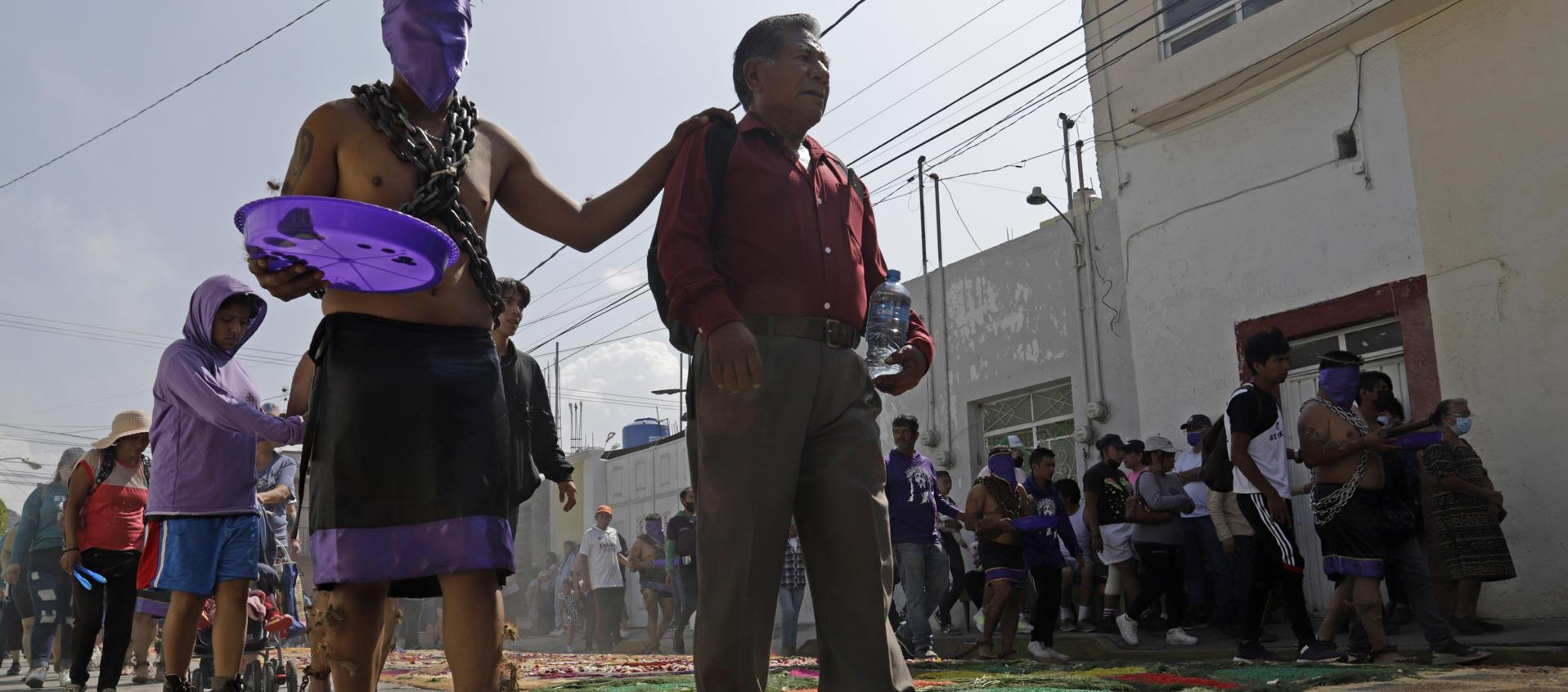 Devotos participan en la procesión de los engrillados este Viernes Santo, durante las celebraciones de Semana Santa, en el municipio de Atlixco, en Puebla.
