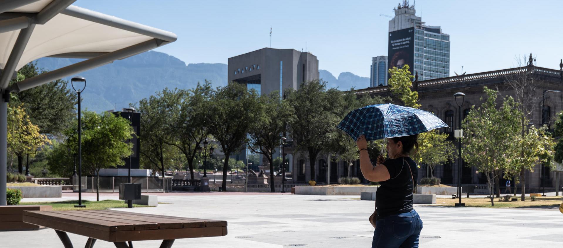 Una mujer sostiene una sombrilla para protegerse del sol, debido a las altas temperaturas en Monterrey, México. 