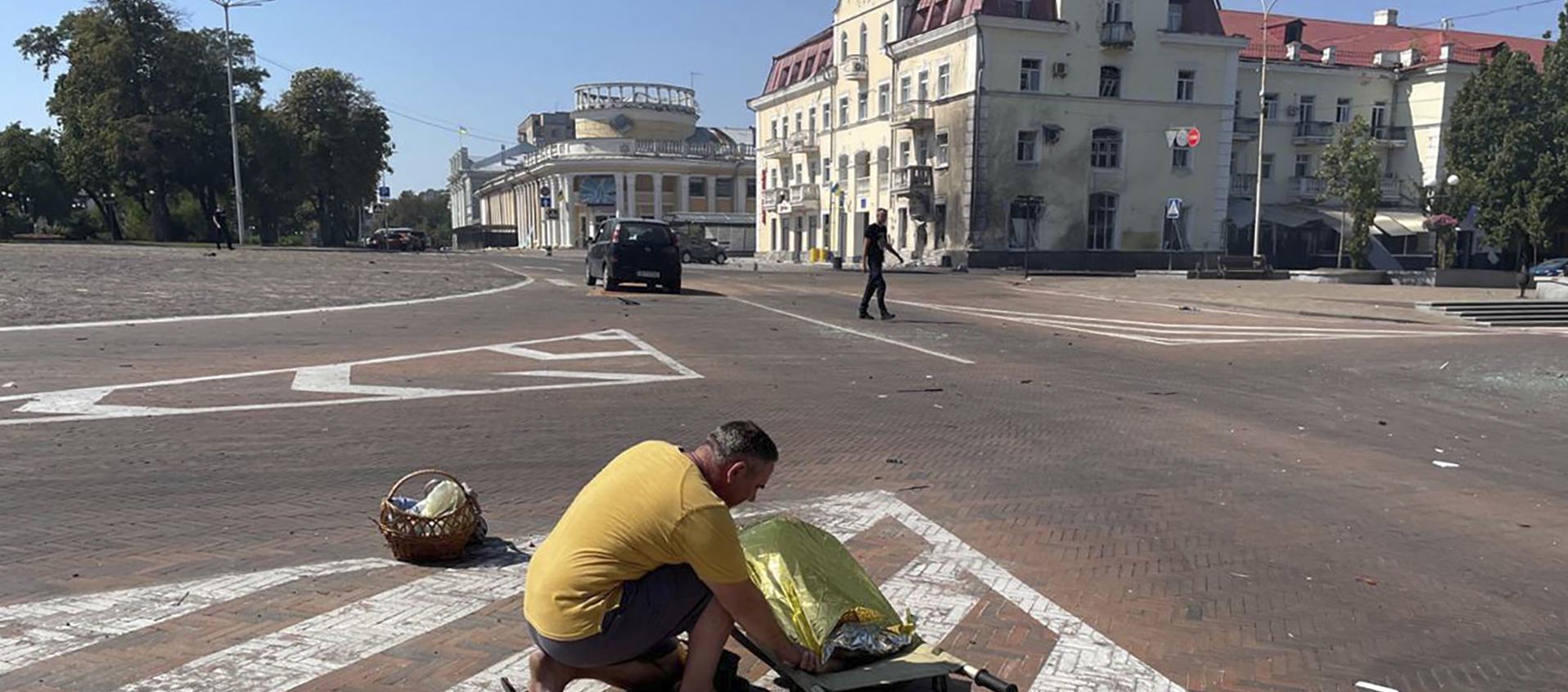  Un hombre junto al cuerpo de una de las víctimas del ataque ruso sobre el centro urbano de la ciudad ucraniana de Chernígov.