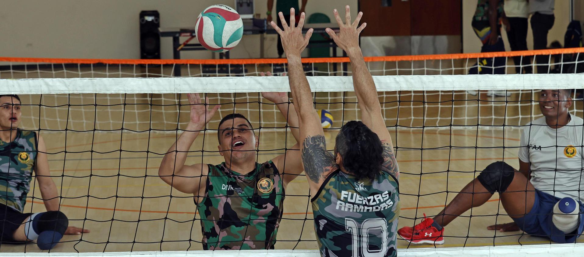 El veterano del Ejército Edward Guerrero (2-i) participa en una práctica de voleibol.