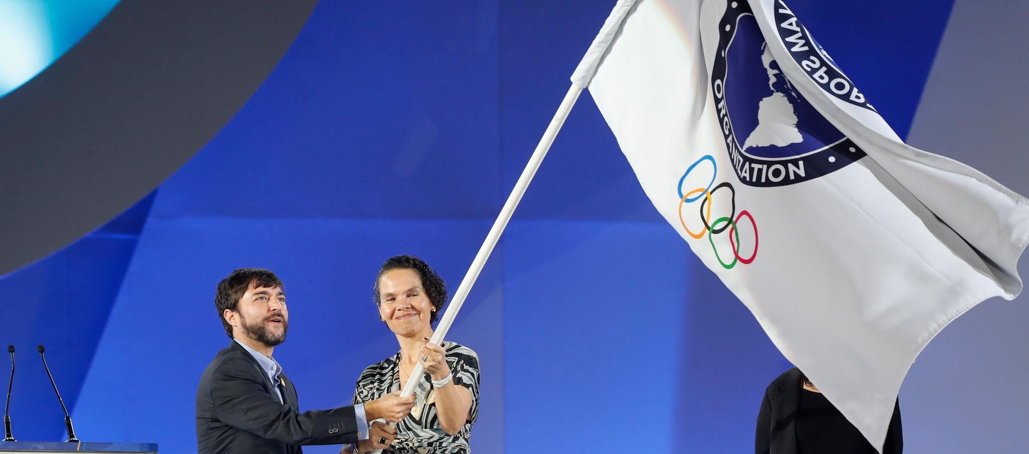 El alcalde Jaime Pumarejo y la ministra del Deporte, Astrid Rodríguez, tras recibir la bandera de los Juegos Panamericanos de 2027. 