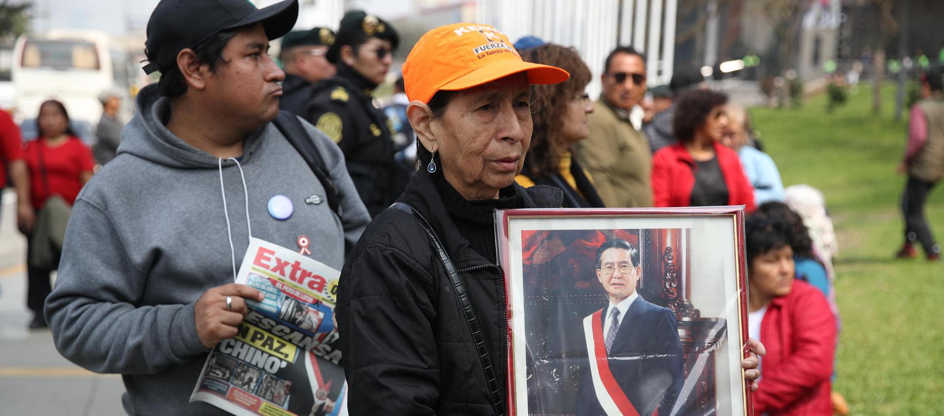 Una simpatizante del fallecido presidente de Perú Alberto sostiene un retrato de Fujimori.