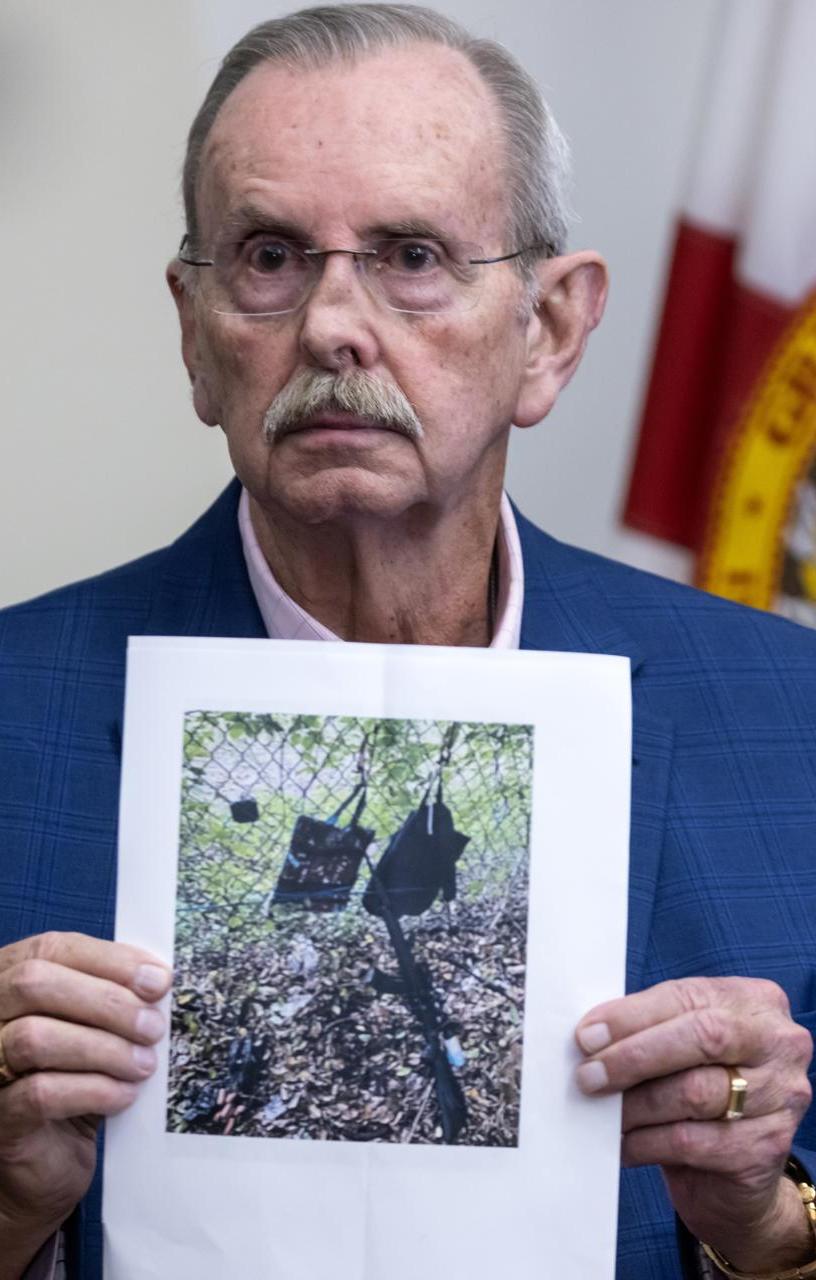 El funcionario Ric Bradshaw muestra una foto de los elementos que se encontraron junto a la valla del campo de golf