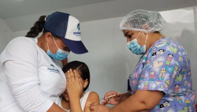 Una funcionaria de salud vacuna a una niña sucreña contra Covid-19.