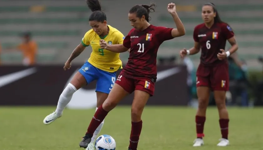 Bárbara Olivieri (c) de Venezuela disputa el balón con Debinha de Brasi
