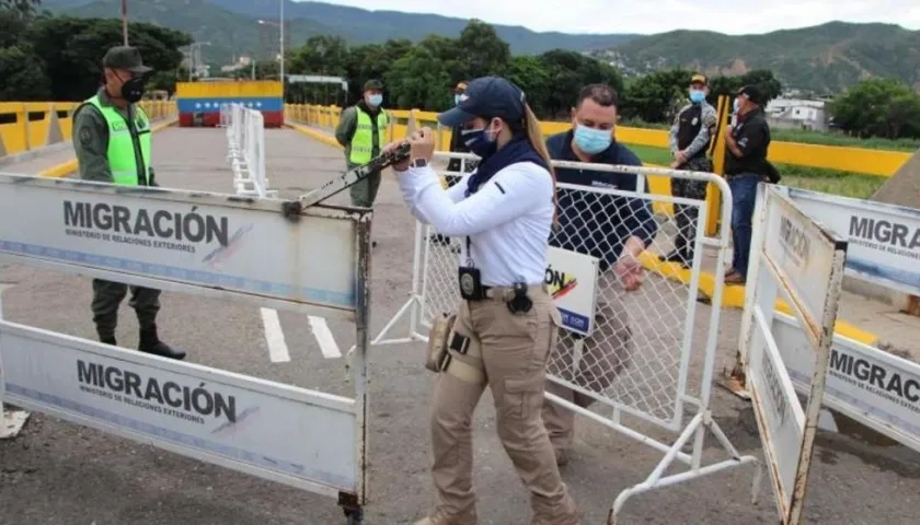 Funcionarios de Migración Colombia quitan las vallas que bloquean el paso fronterizo entre Colombia y Venezuela.