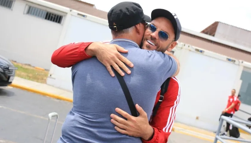 Sebastián Viera se abraza con su padre, Mario, que fue a recibirlo al aeropuerto de Trujillo.