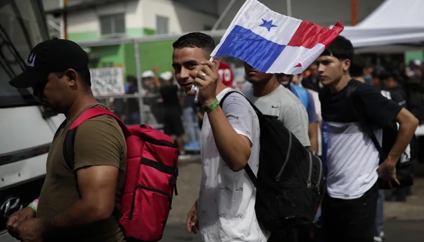 Migrantes de origen venezolano hacen fila para subir a un autobús hacia el aeropuerto internacional de Tocumen en Ciudad de Panamá.