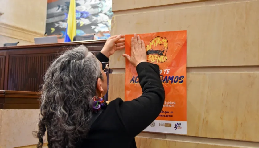 La senadora María José Pizarro pega un cartel en contra del abuso sexual en la sede del Congreso.