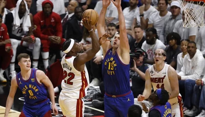 Nikola Jokic intenta bloquear el lanzamiento de Jimmy Butler.