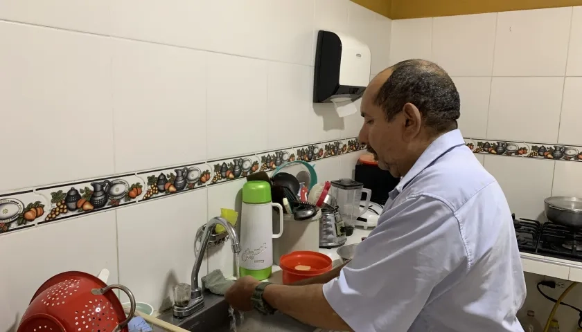 Jorge Madera lavando los platos en su nueva cocina.