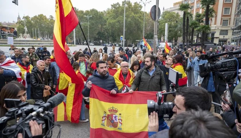 Varias personas con banderas de España protestan en las inmediaciones del Congreso de los Diputados