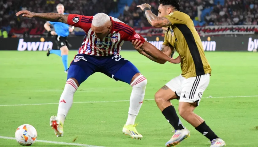 Jermein Peña en un duelo con Marcos Bolados, durante el partido contra Colo Colo.