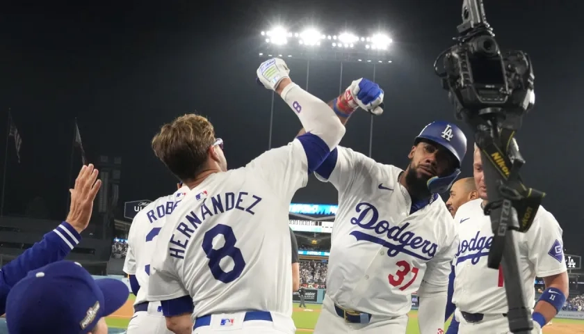 Kiké Hernández se saluda con Teoscar Hernández tras el jonrón de este último en el séptimo inning.