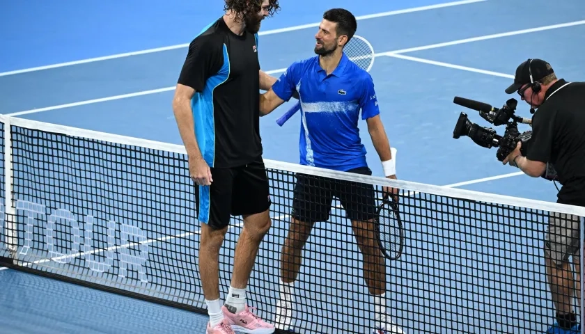 Novak Djokovic felicitando a Reilly Opelka por la victoria.