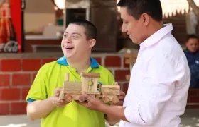 Alegría de un joven con discapacidad al recibir su trencito de madera.