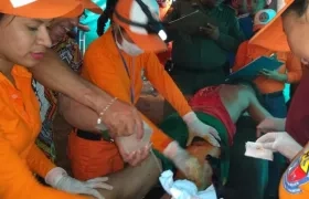 Voluntarios de la Defensa Civil atendiendo a uno de los lesionados.