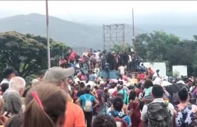 Numerosas personas superando los contenedores dispuestos por el gobierno venezolano en la frontera.
