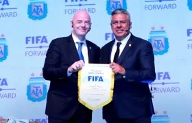 Gianni Infantino entrega un banderín de la FIFA al presidente de la AFA, Claudio Tapia, durante su visita a Argentina.