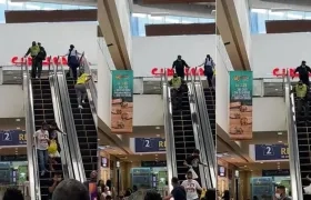 Los dos ladrones, uno vestido de policía, cuando bajaban corriendo por la escalera eléctrica del centro comercial. 