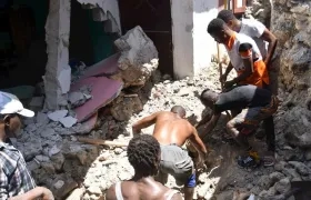 Un grupo de personas remueve escombros tras el terremoto en Haití.