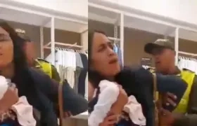 Con su bebé en brazos, Wendy Norelys fue sacada esposada del almacén en Cartagena.