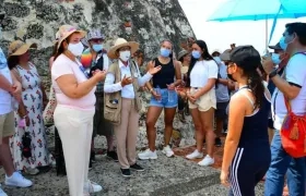 Turistas escuchan a una guía en el Castillo de San Felipe.
