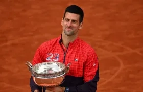 Novak Djokovic besa el trofeo que lo convierte en el más ganador de torneos de Grand Slam. 