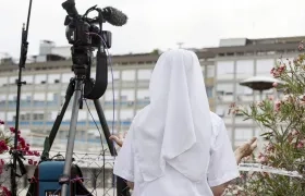 Imagen de archivo de una religiosa rezando por la salud del papa frente a la clínica donde estaba ingresado el pontífice durante una reciente hospitalización