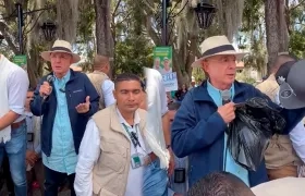 Álvaro Uribe Vélez sacando las gorras compradas.