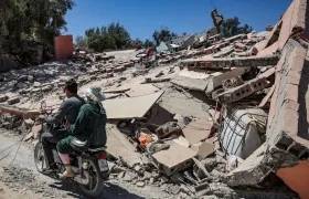 Dos motorizados pasan frente a los destrozos que dejó el terremoto en Marruecos