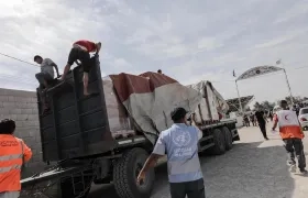 Funcionarios de la Media Luna Roja palestina ayudan a descargar la ayuda para la Franja de Gaza