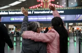Dos mujeres despiden a familiares en el aeropuerto El Dorado de Bogotá