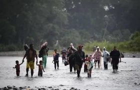 Migrantes cruzan el río Turquesa, en Darién (Panamá).