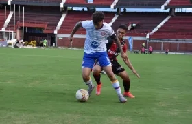 El uruguayo Cristian Sención, del Unión Magdalena, intenta librarse de la marca de un contrario.
