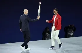 Zinedine Zidane entrega la antorcha olímpica al tenista español Rafael Nadal. 