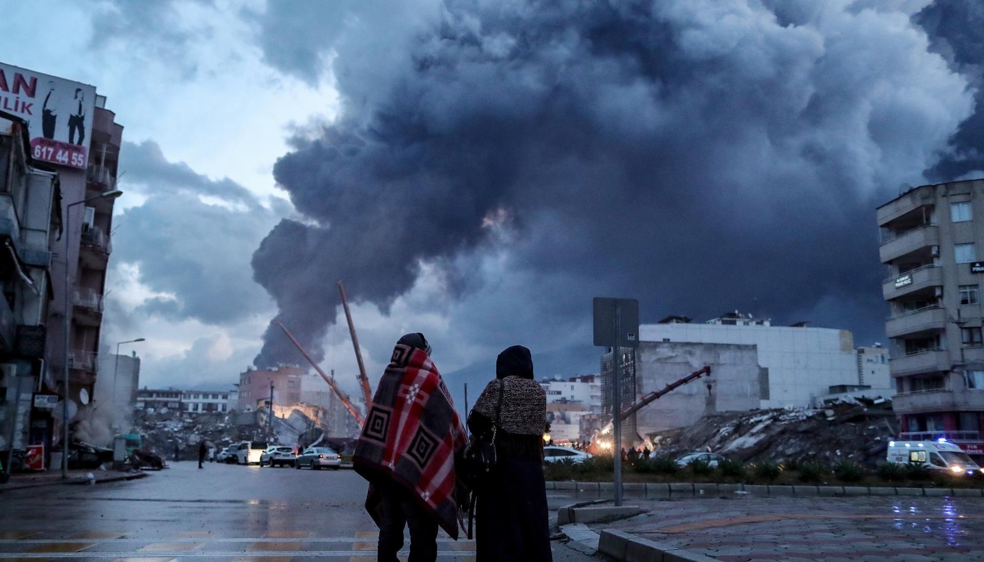 Dos personas observan los destrozos ocasionados por los terremotos en Hatay, Turquía