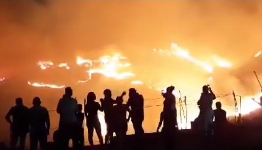Personas observan las llamas que han arrasado 60 hectáreas de material vegetal en Cali