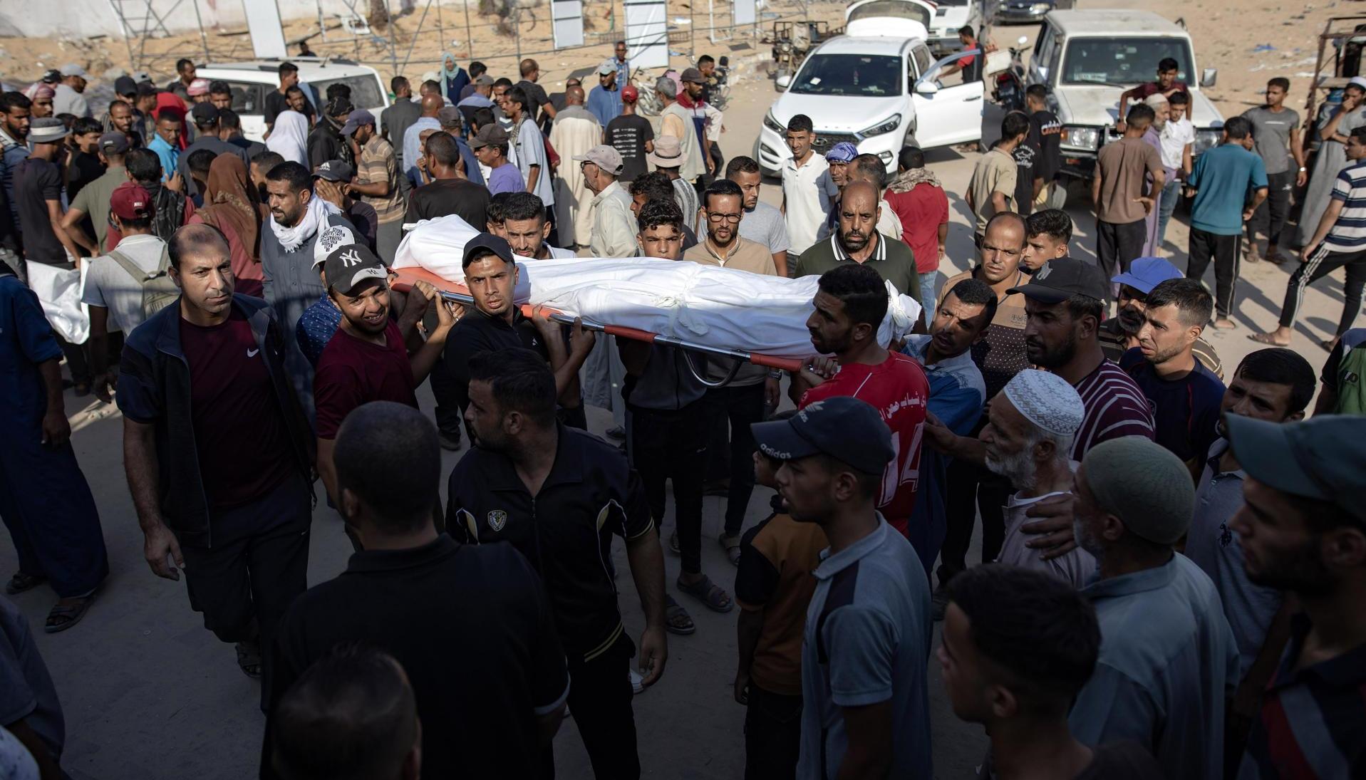 Palestinos levantan el cadáver de uno de los fallecidos.