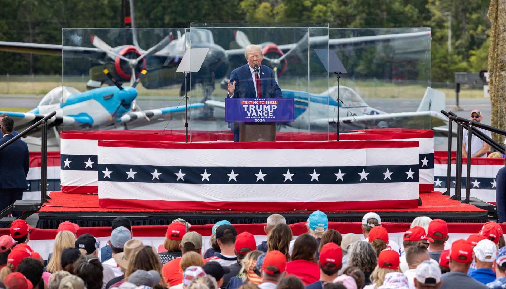 Donald Trump ofreciendo un discurso protegido con vidrios antibalas. 