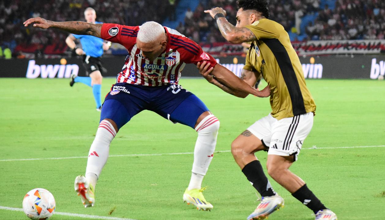 Jermein Peña en un duelo con Marcos Bolados, durante el partido contra Colo Colo.